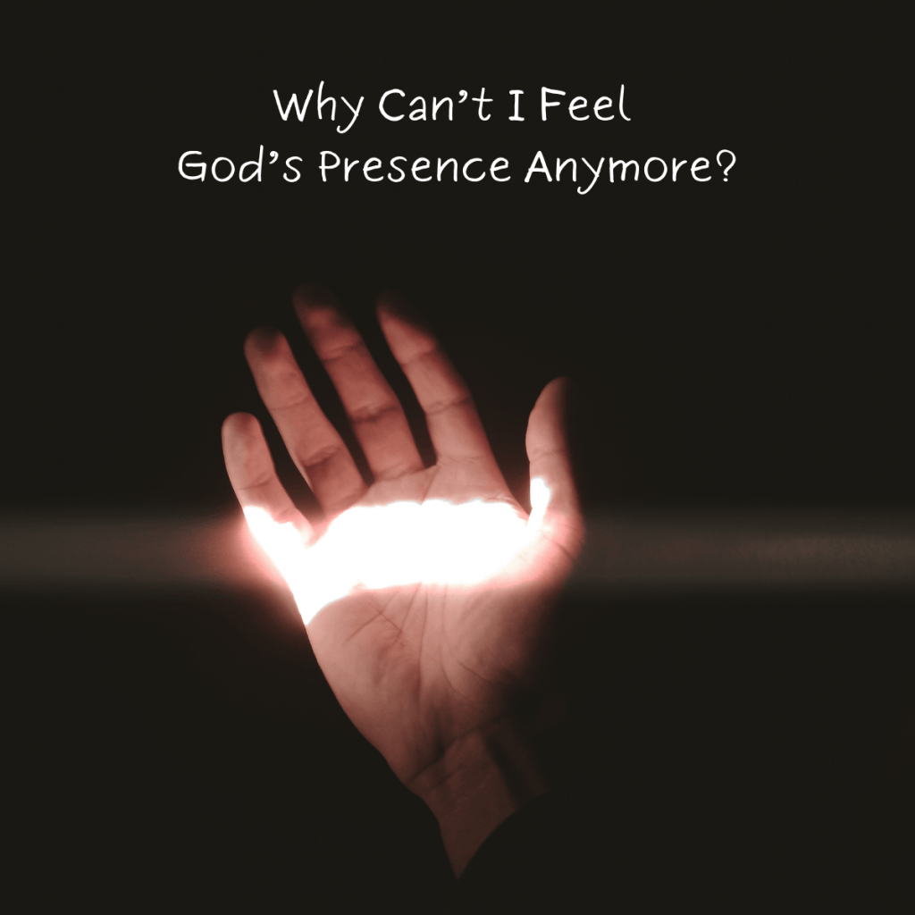 A hand reaching into the darkness, illuminated by a beam of light, symbolizing the struggle of not feeling God’s presence. The text overlay reads, "Why Can’t I Feel God’s Presence Anymore?", reflecting a spiritual crisis and feelings of distance from God.