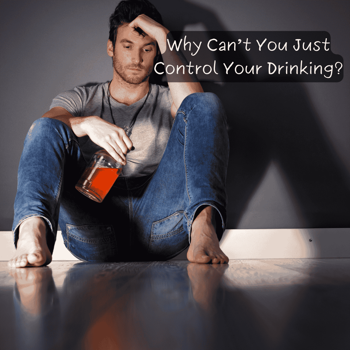 A barefoot man sits on the floor against a wall, holding a bottle of alcohol with a distant, troubled expression. The text overlay reads, "Why Can’t You Just Control Your Drinking?"—highlighting the struggles of alcohol addiction and the misconceptions around it.