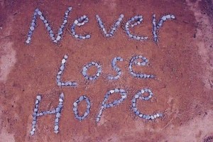 beach with "never lose hope" written using rocks